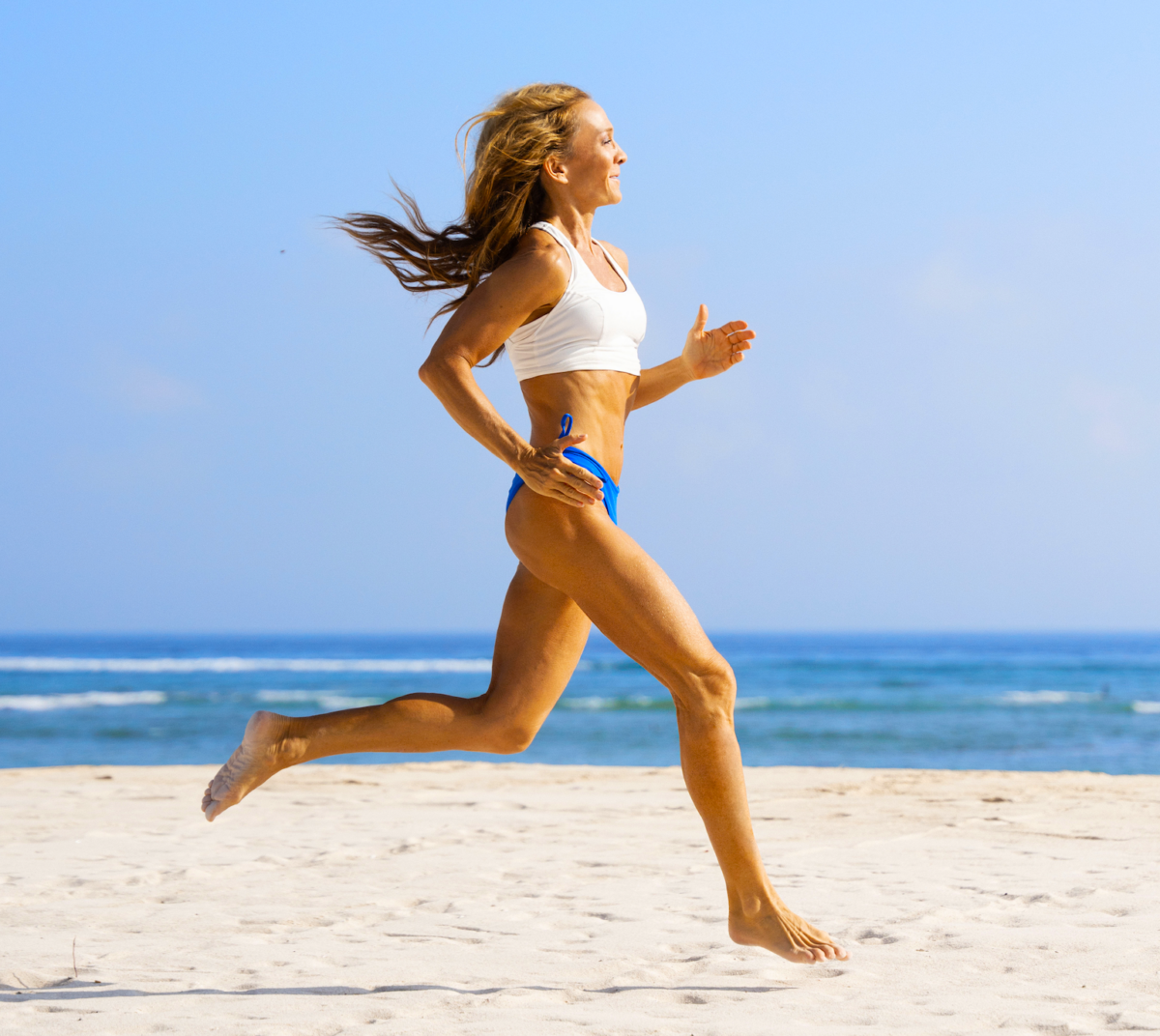 Fit woman running on sand hovering above ocean symbolizing squirting